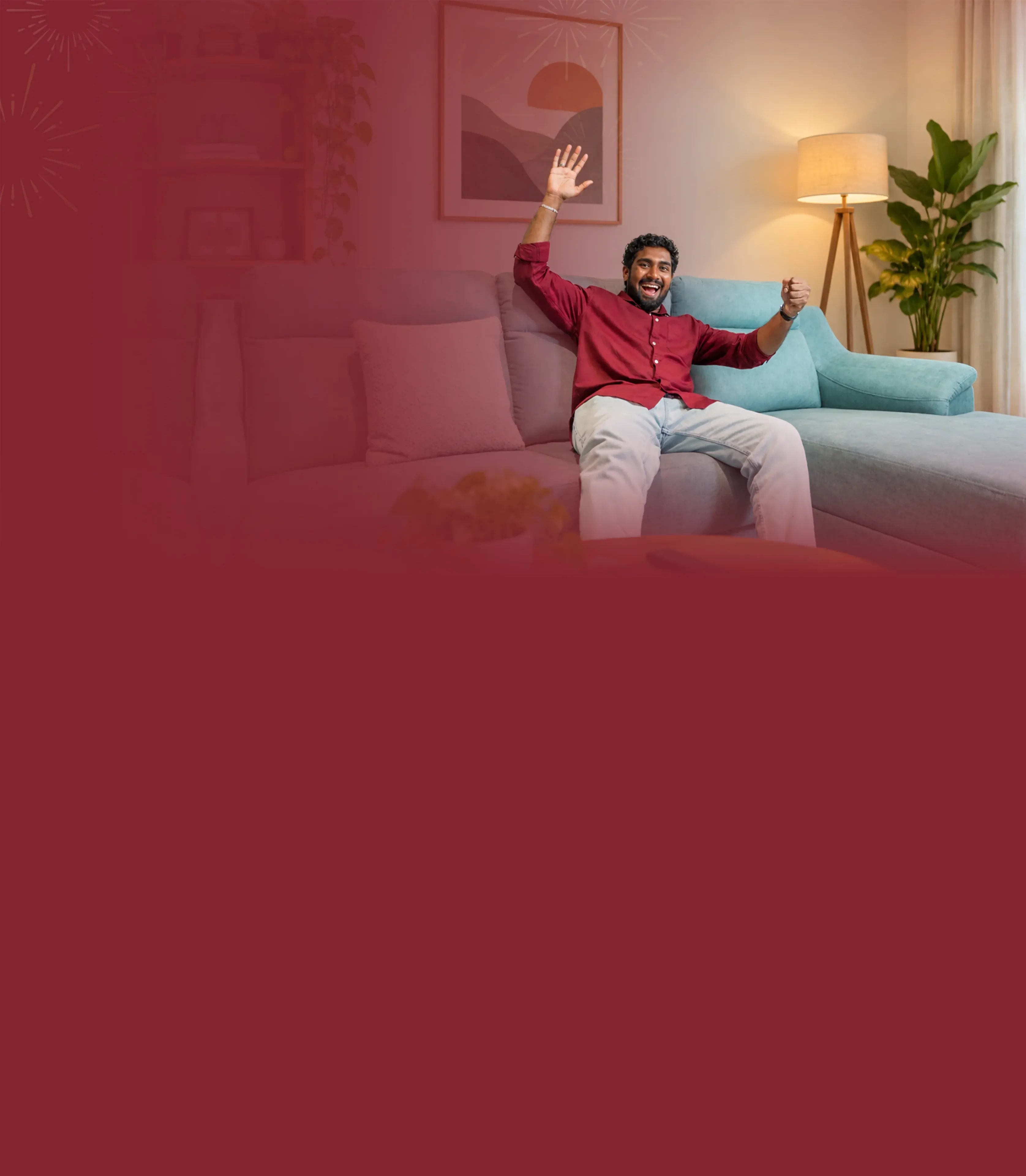 A happy man cheering on a new teal sofa in a warmly lit living room